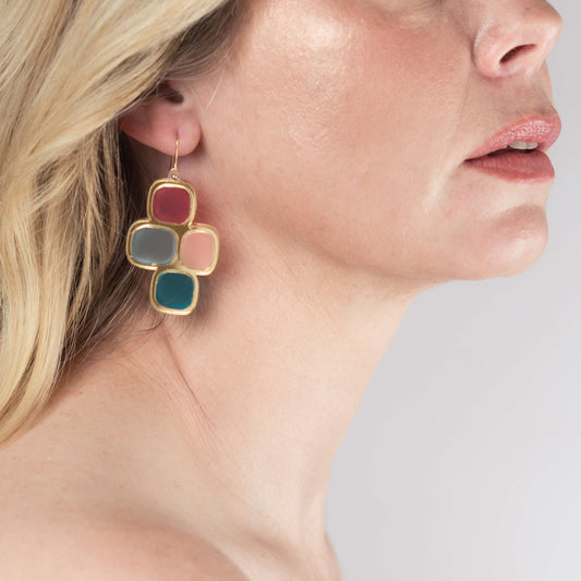 Model wearing frosted statement wire earrings in gold and mixed hues