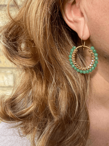 Close up model wearing green statement earrings