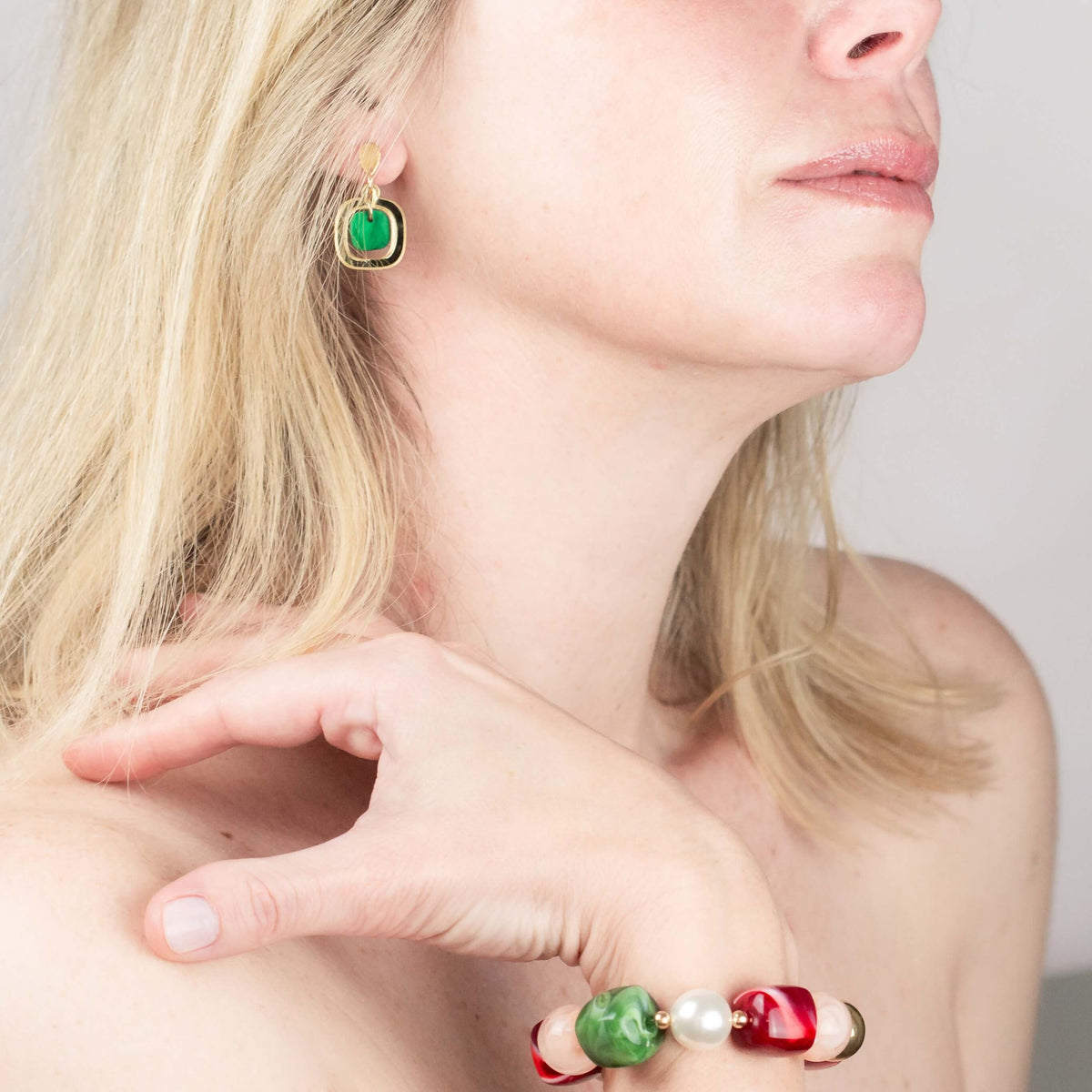 Woman wearing Hélène Elisabeth gold-plated statement earrings and bracelet jewellery set in green, red and pearl