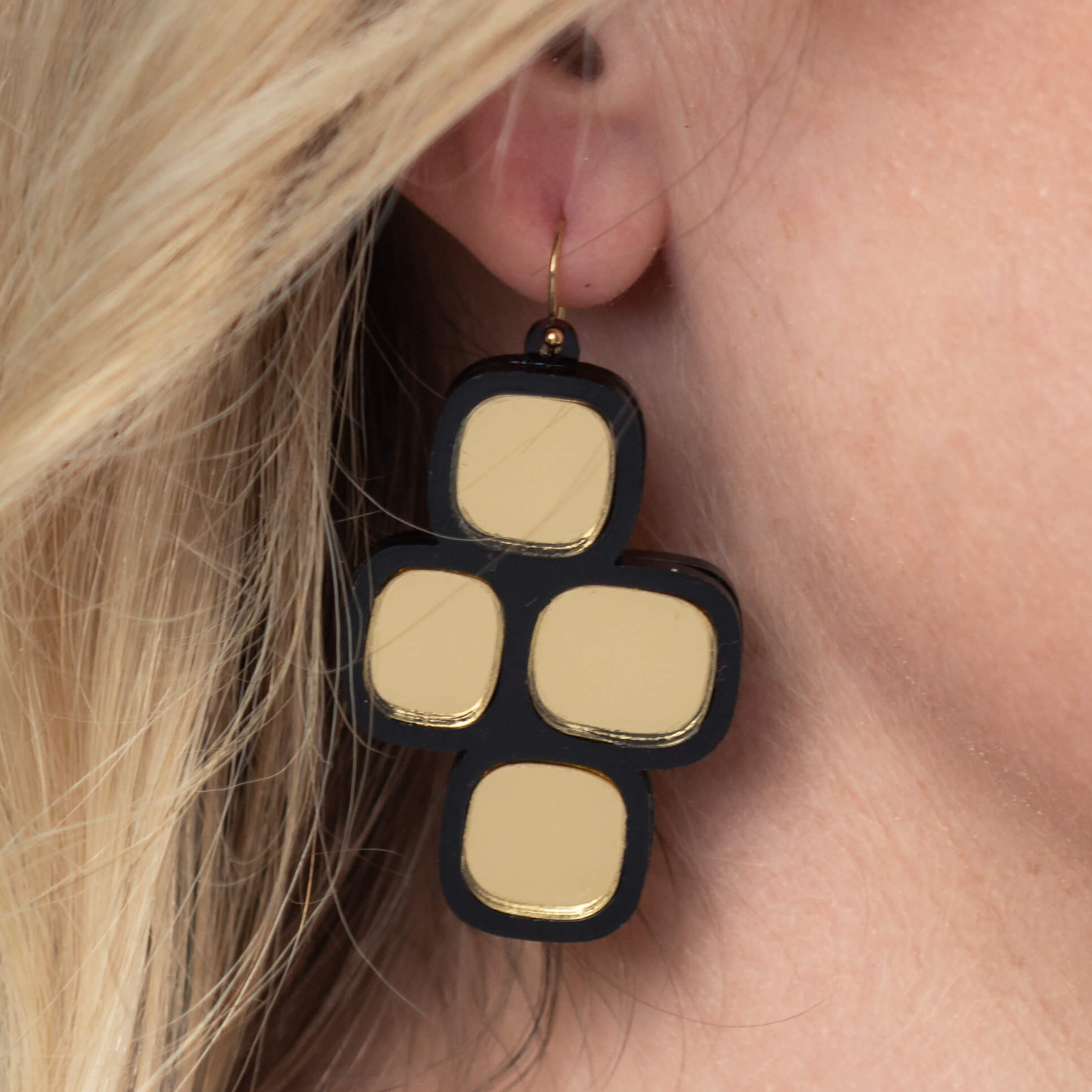 Close-up of model’s ear wearing mirror statement wire earrings