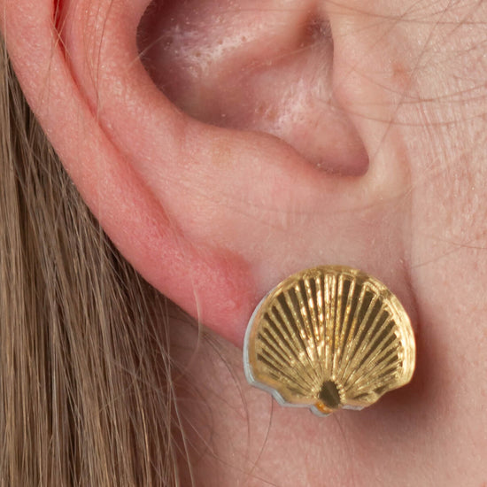Close-up of model’s ear wearing shell bridesmaid earrings
