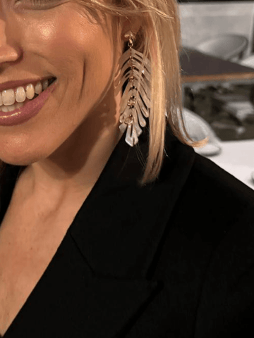 Close up model wearing white statement earrings