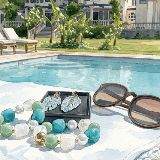 Capsule holiday wardrobe flat lay — ocean turquoise leaf earrings and statement beaded bracelet by Hélène Elisabeth, shot at Villa Kittera Biarritz