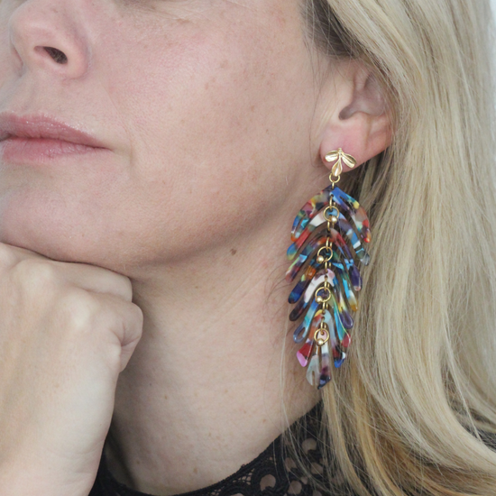 Blond woman wearing Tutti Frutti colourful long leaf earrings, colourful earrings by Hélène Elisabeth, Rêves de Paradis collection