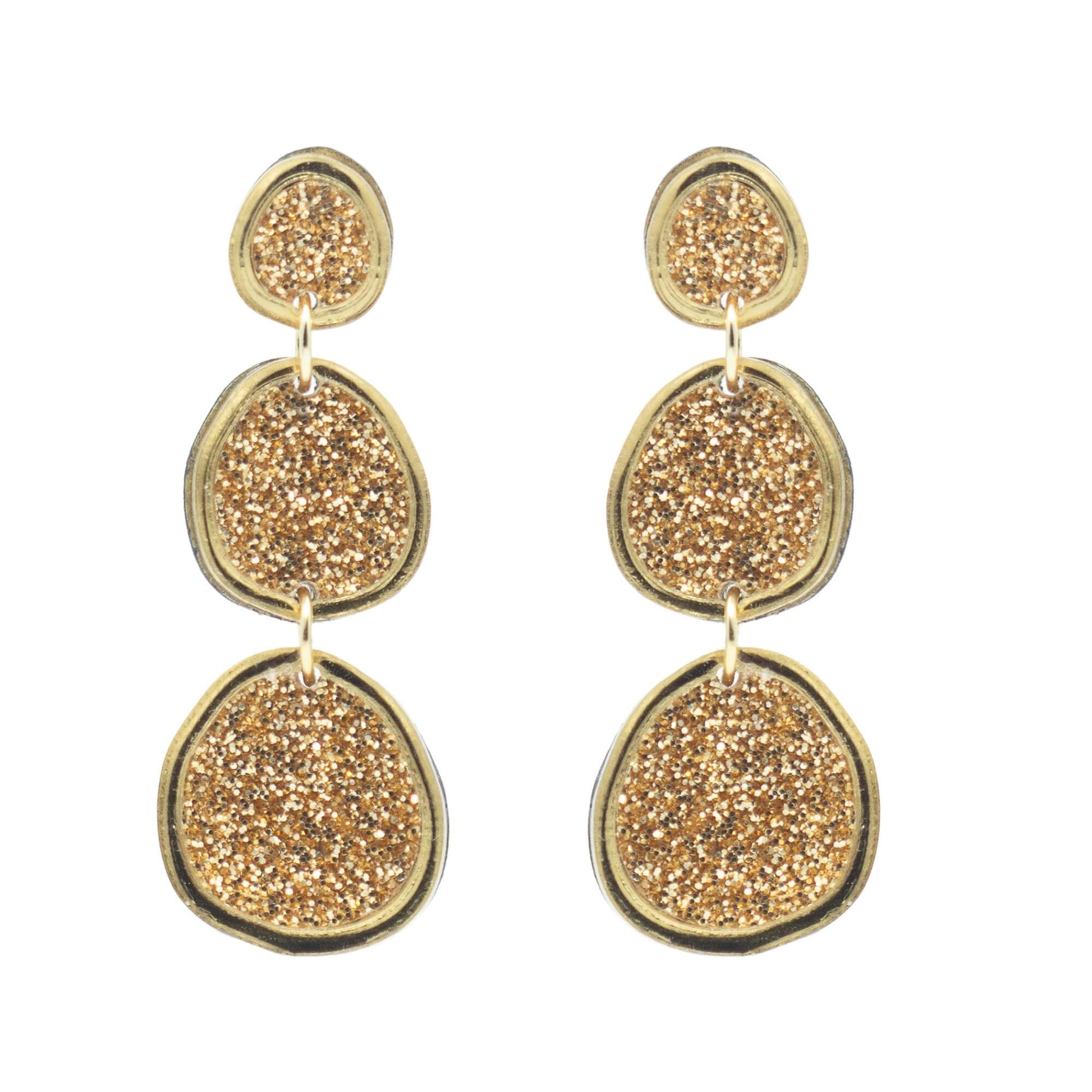 Shimmering gold statement earrings on white background